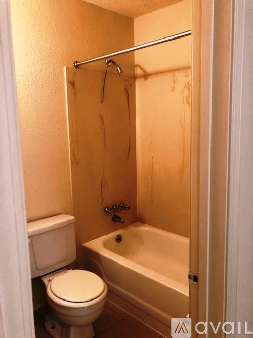 A small bathroom with a toilet, tub, and shower.