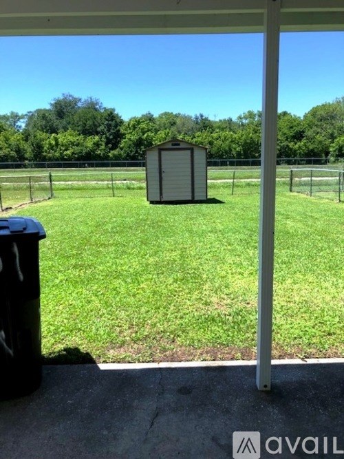 A small building sits in the middle of a grassy field.