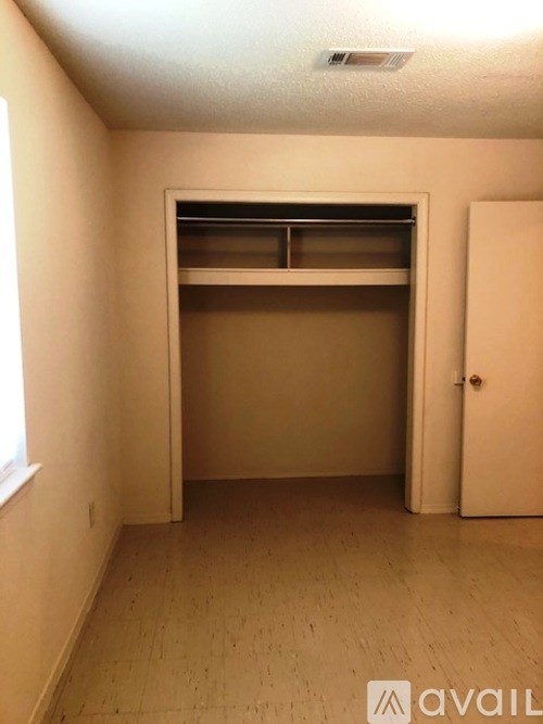 A room with a white door and a window on the left side.