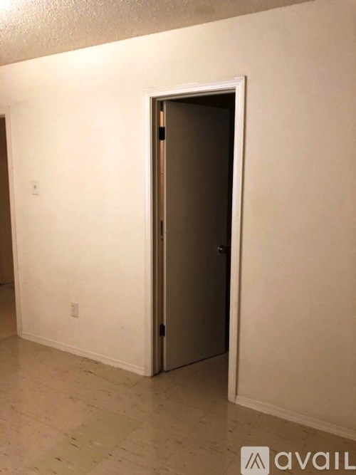 A room with a door and a wall socket.