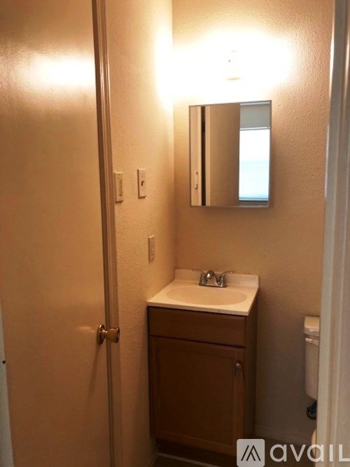 A bathroom with a sink, mirror and towel rack.