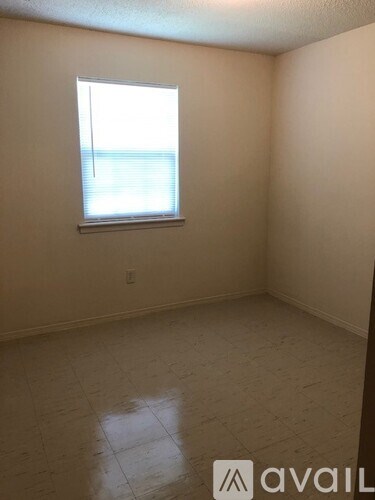 A room with a window and tiled floor.