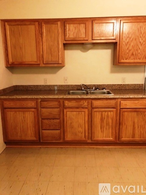 A kitchen with wooden cabinets and a granite countertop.