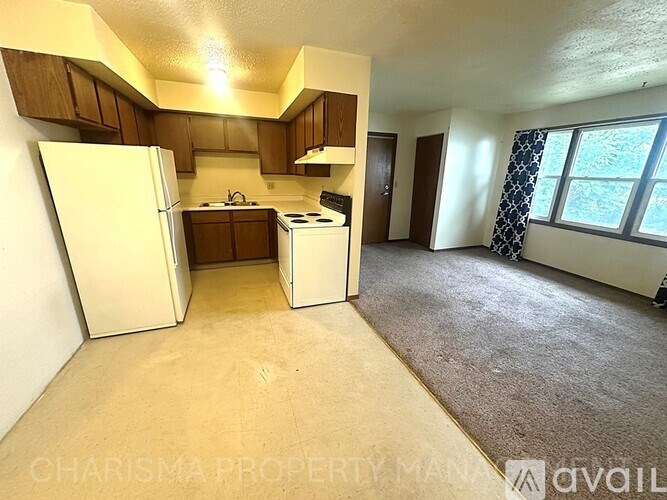 A kitchen with white appliances and wooden cabinets.