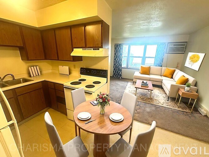 A well-lit kitchen and living room with a dining table set for two.