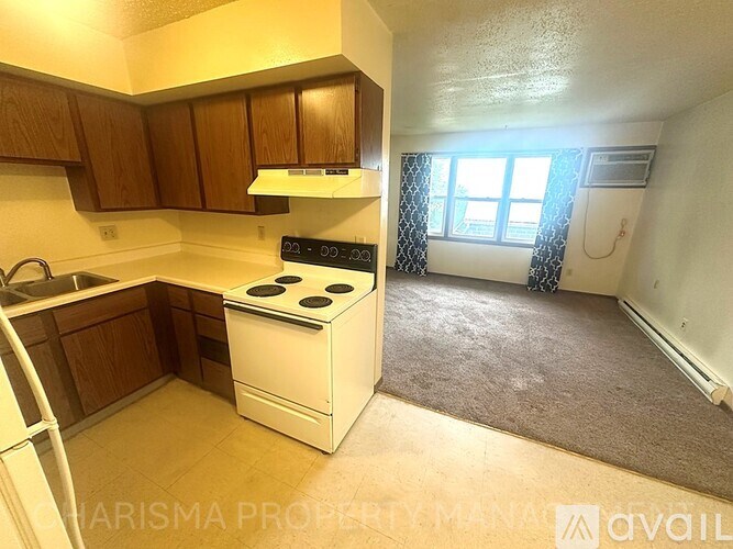 A kitchen with a white stove and wooden cabinets.