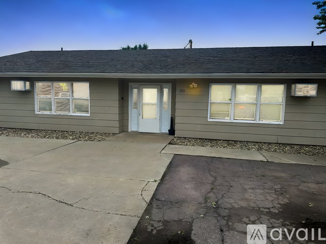 A house with a grey roof and a blue door is available for rent.
