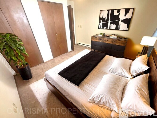 A bedroom with a bed, nightstand, and lamp.