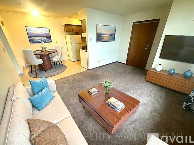 A living room with a couch, a coffee table, and a television.