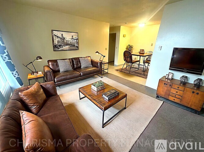 A living room with a brown leather couch and a coffee table.