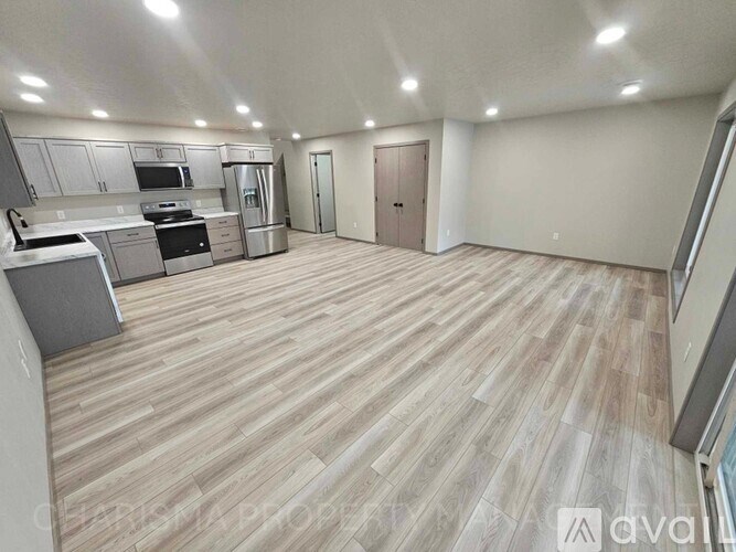 A spacious kitchen with wooden flooring and modern appliances.
