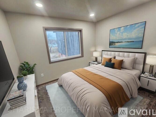 A bedroom with a large bed and a painting on the wall.