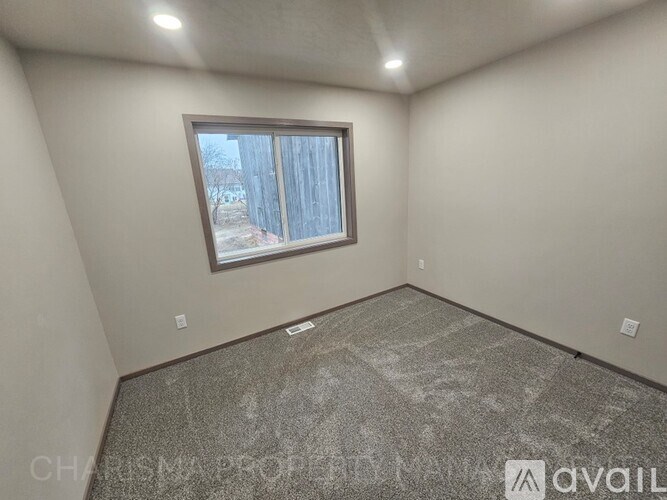 A room with a window and a floor that looks like it needs to be cleaned.