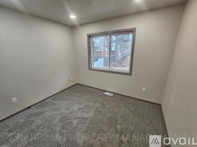A room with a window and carpeted floor.