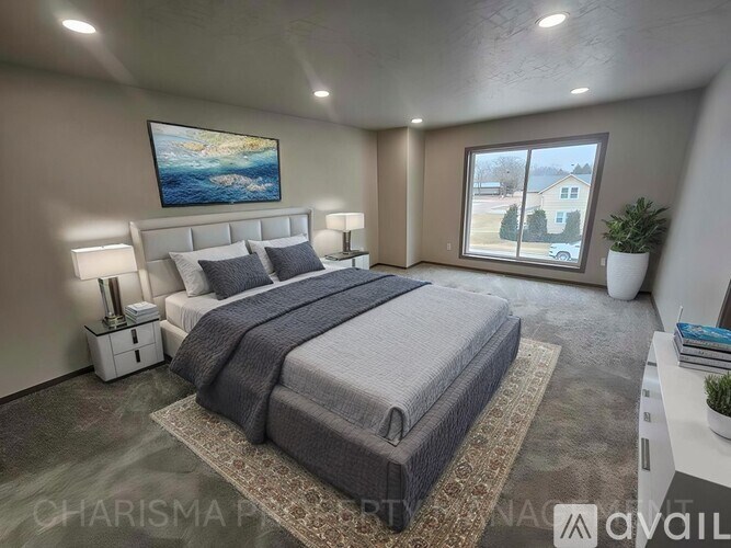 A bedroom with a large bed, two nightstands, and a painting on the wall.