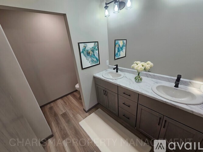 A bathroom with a sink, mirror, and a white flower.