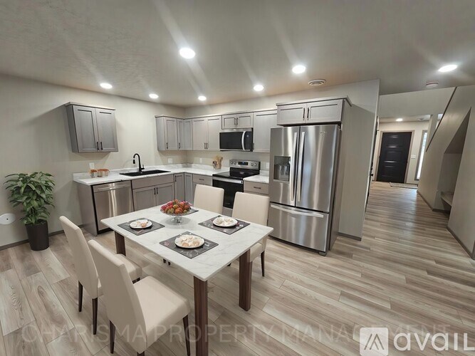 A modern kitchen with a dining table set for two.