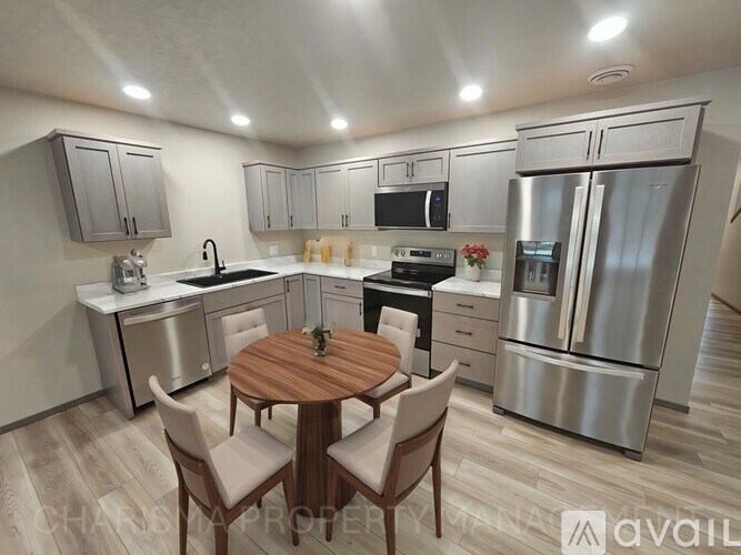 A modern kitchen with a wooden table and chairs.