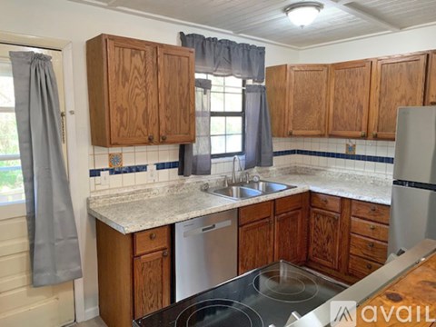 A kitchen with wooden cabinets and a stainless steel dishwasher.