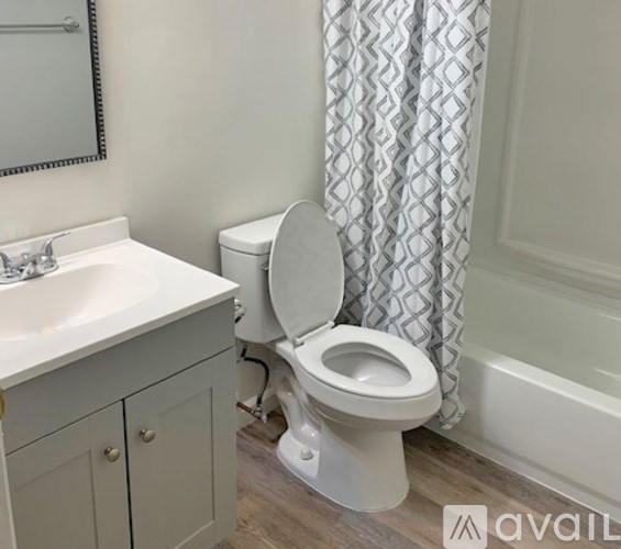 A white toilet with a white sink and a white cabinet in a bathroom.