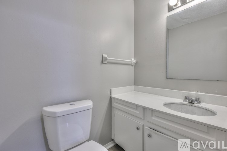 A white toilet sits next to a white sink in a bathroom.