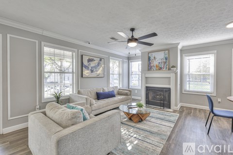 A living room with a grey couch and a fireplace.