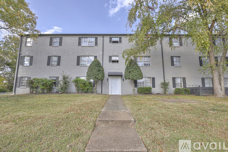 A building with a white door and windows with trees in front.