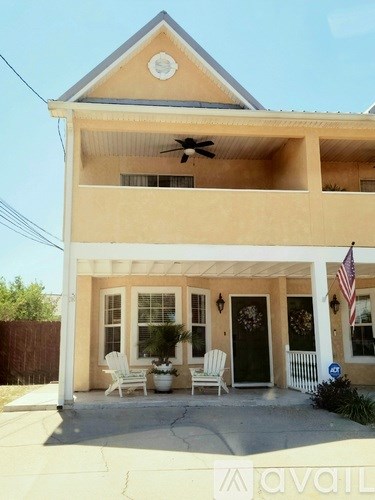 A house with a balcony and a fan on the roof.