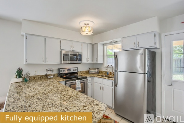 A fully equipped kitchen with granite countertops and stainless steel appliances.