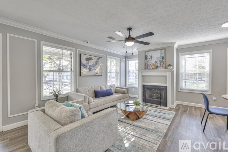 A living room with a grey couch and a fireplace.