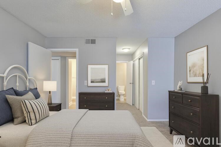 A spacious room with wooden flooring and a white wall.