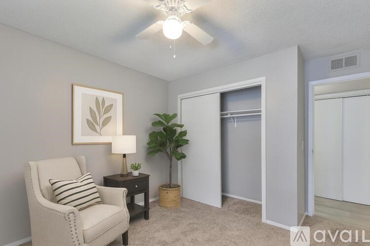 A room with a ceiling fan and a window with blinds.