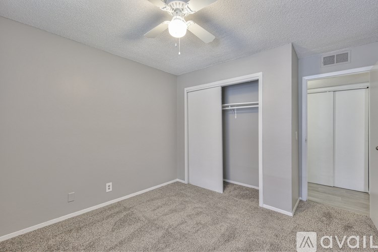 A room with a ceiling fan and carpeted floor.