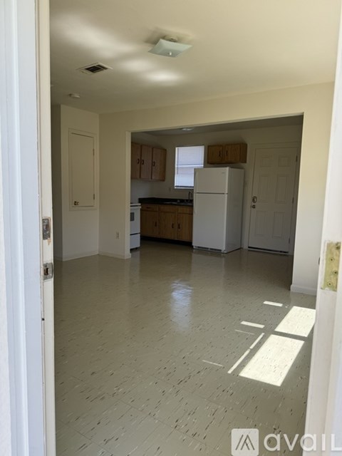 A kitchen with white cabinets and a white refrigerator.