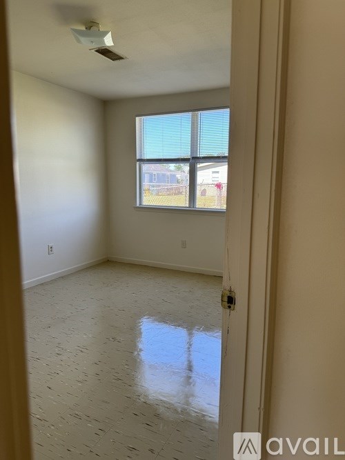 A room with a window and a tiled floor.