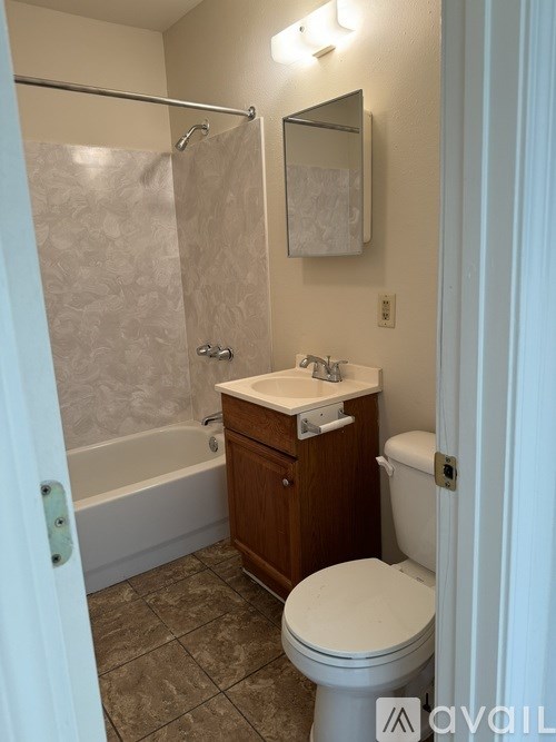 A small bathroom with a toilet, sink and shower.