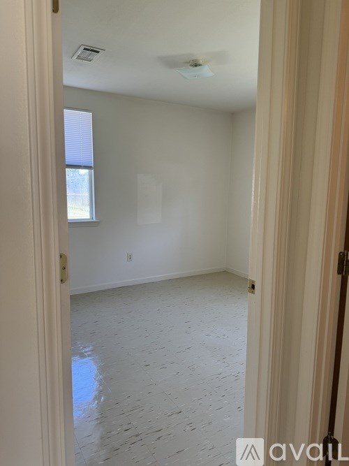 A room with a tiled floor and a window is available for rent.