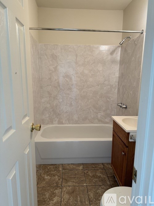 A bathroom with a bathtub, toilet, and sink.