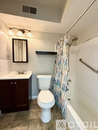 A bathroom with a toilet, sink, and shower.