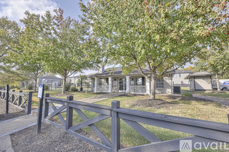 A wooden fence in front of a house with trees.
