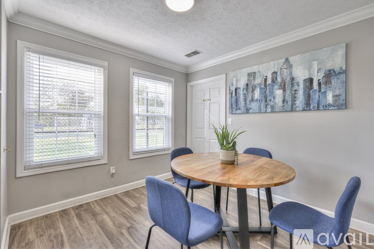 A room with a round table and blue chairs.