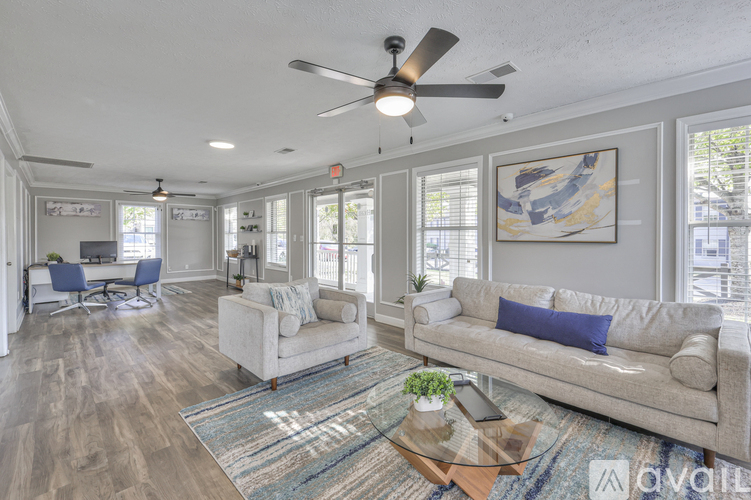A living room with a couch, chairs, and a rug.