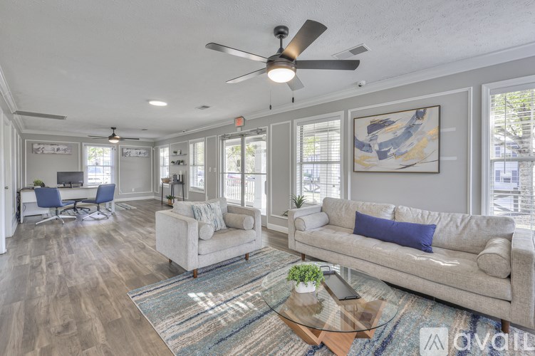 A living room with a couch, chairs, and a rug.