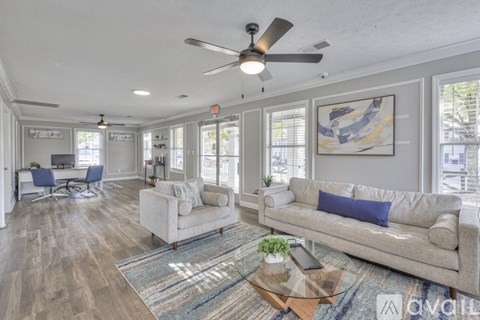 A living room with a couch, chairs, and a rug.