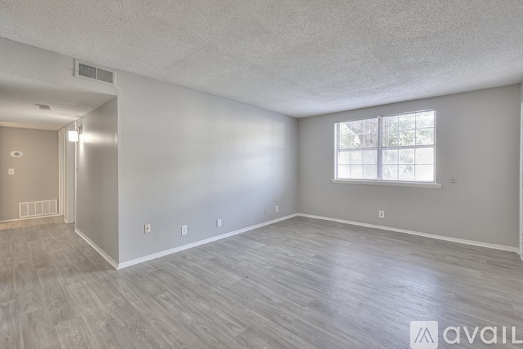 A room with a window and wooden flooring is available for rent.