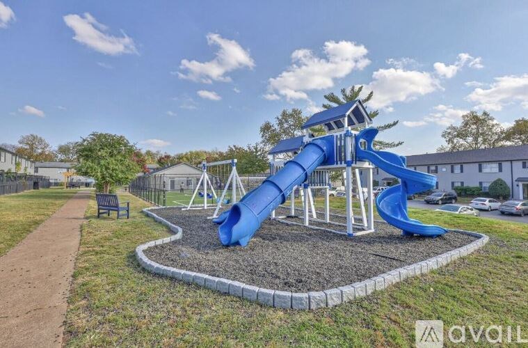 A playground with a blue slide and a wooden structure.