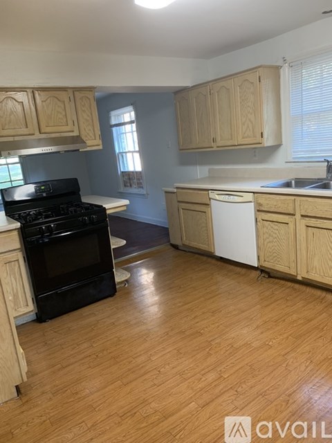 A kitchen with wooden cabinets and a black stove top oven.