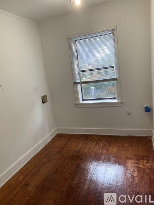 A room with a window and wooden flooring.