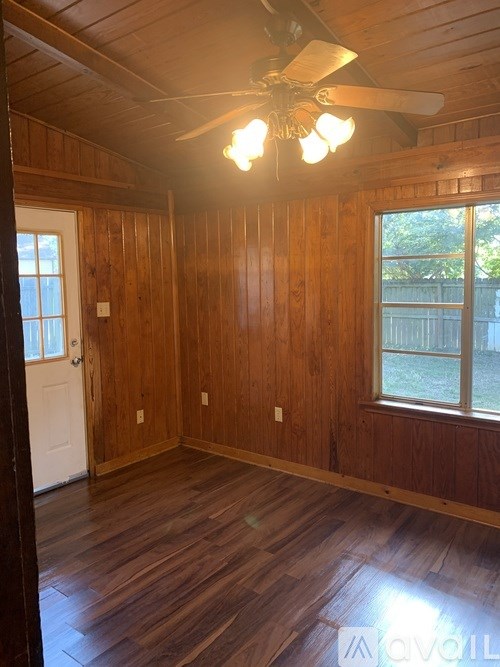 A room with wooden walls and a ceiling fan.