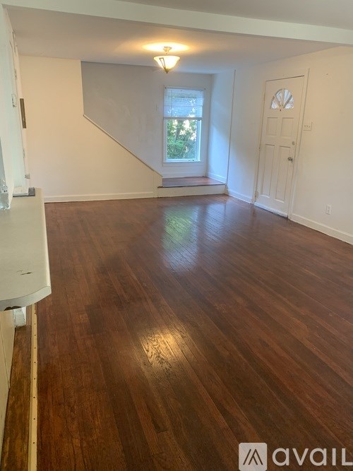 A room with wooden flooring and a window.